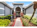 Beautiful arched double door entry with stone accents and lush landscaping leading to the home at 1640 Wild Indigo Ter, Oviedo, FL 32766