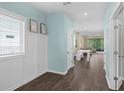 Inviting entryway with coat storage nook, light blue walls and adjacent view into a living and dining space at 17860 Passionflower Cir, Clermont, FL 34714