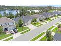 A high angle, long view of several upscale homes on manicured lawns near a lake on an overcast day at 17860 Passionflower Cir, Clermont, FL 34714