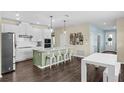 Bright kitchen featuring white cabinets, stainless steel appliances, a green island, and a breakfast bar seating four at 17860 Passionflower Cir, Clermont, FL 34714