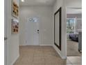 Welcoming foyer with neutral tile flooring, art decoration and a view leading into the bedroom at 1935 Majorca Dr, Kissimmee, FL 34747