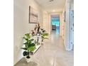 Inviting hallway featuring tile floors, neutral paint, and stylish decor leading to living areas at 2033 E Gloria Dr, Deltona, FL 32725