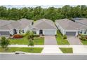 An aerial view of a gray home, featuring well-manicured landscaping and a brick-paved driveway at 2698 River Creek Ln, St Cloud, FL 34771