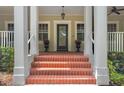Welcoming front porch with brick steps, stately columns, and potted flowers at the entry at 315 Desoto Cir, Orlando, FL 32804