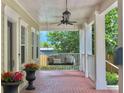 Inviting covered porch features a swing seat, ceiling fan, and potted flowers at 315 Desoto Cir, Orlando, FL 32804