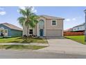 Charming two-story home featuring a well-maintained lawn, a large palm tree, and a two-car garage at 328 Fairfield Dr, Sanford, FL 32771
