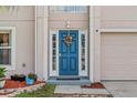 Charming blue front door with sidelights and decorative wreath and a two-car garage on the side at 328 Fairfield Dr, Sanford, FL 32771