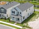 Aerial view of a modern two-story home, showcasing the roof, landscaping, and proximity to a pond at 353 Belmond Dr, Debary, FL 32713