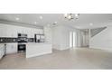 Bright, open-concept kitchen featuring white cabinets, stainless steel appliances, and tile flooring at 353 Belmond Dr, Debary, FL 32713