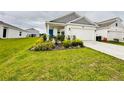 Well-manicured lawn and garden beds enhance the curb appeal of this lovely single Gathering home at 4295 Twisted Twig Bnd, Kissimmee, FL 34746