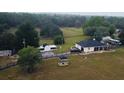 Expansive property featuring a home with a dark roof, a white barn-style building, and lush green surroundings at 4805 Sw 171St Ct, Dunnellon, FL 34432