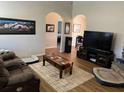 Comfortable living room with hardwood floors, a plush sofa, and an entertainment center with a large TV at 4805 Sw 171St Ct, Dunnellon, FL 34432