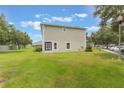 Rear exterior view of townhome with a lush green lawn, and neutral color, showing ample outdoor space at 9492 Flowering Cottonwood Rd # 82, Orlando, FL 32832
