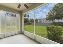 Relaxing screened patio overlooking a green backyard, perfect for outdoor enjoyment with a ceiling fan at 9492 Flowering Cottonwood Rd # 82, Orlando, FL 32832