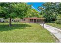 View of the home's facade featuring a covered carport, lawn, and a chain-link fence at 102 Mayrose Dr, Sanford, FL 32771