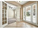 Welcoming entryway featuring neutral tones, tile flooring, and a view of a sunlit office space at 13943 Caywood Pond Dr, Windermere, FL 34786