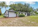 Landscaped single-story home featuring black trimmed windows and mature trees at 18015 Beach St, Umatilla, FL 32784