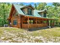 Rustic log cabin featuring a covered front porch and lush natural surroundings at 187 N Samsula Dr, New Smyrna Beach, FL 32168