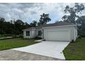 Charming single-story home with a gray roof and a freshly-poured white driveway at 1889 15Th St, Orange City, FL 32763
