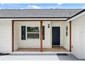 Inviting front entry with covered porch, decorative wood columns, and blue front door and shutter details at 2089 Sunderland Rd, Maitland, FL 32751