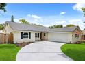 Charming single story home with a winding driveway, lawn, and updated paint, garage and mature trees at 2089 Sunderland Rd, Maitland, FL 32751