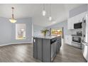 Well-designed kitchen with gray island, pendant lights, and stainless steel appliances at 2181 Jessa Dr, Kissimmee, FL 34743