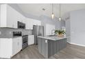 Modern kitchen featuring stainless steel appliances, white cabinets, and a gray island at 2181 Jessa Dr, Kissimmee, FL 34743