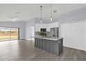 Open kitchen with gray island and white cabinets flows into a bright living area at 2181 Jessa Dr, Kissimmee, FL 34743