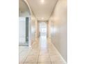 Bright hallway with tiled floors and arched doorways creating an open and inviting atmosphere at 313 Sofia Ln, Lake Alfred, FL 33850