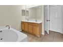 Bathroom featuring double sinks, tiled floors, and a soaking tub at 3322 Park Branch Ave, Clermont, FL 34711