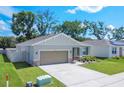 Aerial view of the single-story home with a well-manicured lawn and a long driveway leading to the two car garage at 3964 Mayhill Loop, Eustis, FL 32736