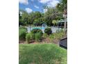 Community pool area with a splash pad, lush landscaping, black aluminum fencing and a covered gazebo at 406 Cool Summer Ln, Davenport, FL 33837