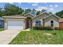 Lovely single-story home with attached garage, manicured front yard, and welcoming facade at 419 Cierra Oaks Cir, Lady Lake, FL 32159