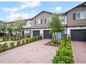 Street view of charming townhomes with brick driveways, garages and manicured landscaping at 463 Cape Honeysuckle Pl, Sanford, FL 32771