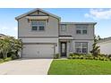 Well-maintained two-story home with manicured lawn, gray siding, and an attached two-car garage offers great curb appeal at 5065 Sparkling Water Way, Kissimmee, FL 34746
