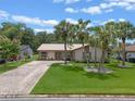 Charming single-story home featuring a beige exterior, metal roof, and a well-manicured lawn at 708 Duffer Ln, Kissimmee, FL 34759