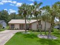 Inviting single-story home featuring a beige exterior, metal roof, and a well-manicured lawn at 708 Duffer Ln, Kissimmee, FL 34759