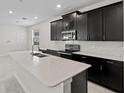Modern kitchen featuring sleek black cabinetry, stainless steel appliances, and a spacious center island at 9069 Pinch Shot Dr, Winter Garden, FL 34787