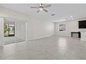 Bright and open living room with tile flooring, a ceiling fan, and sliding glass doors to the patio at 9069 Pinch Shot Dr, Winter Garden, FL 34787