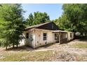 Side exterior view of a home surrounded by mature trees and an attached porch at 9536 Peer Dr, Orlando, FL 32817