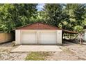 Detached two-car garage with white doors, brown trim and lean-to at 9536 Peer Dr, Orlando, FL 32817