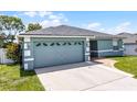 Home exterior featuring a well manicured lawn, brick walkway and driveway, and a two-car garage at 141 Winsor Ave, Davenport, FL 33837