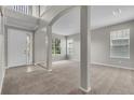Bright living room featuring neutral paint, carpet, and architectural pillars at 14342 Fieldstone Lake Way, Orlando, FL 32824