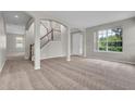Open living room showcasing a staircase, front door and natural lighting at 14342 Fieldstone Lake Way, Orlando, FL 32824