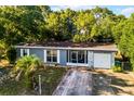 Aerial view of a charming one-story home with a screened porch, garage, tidy front yard and patterned concrete driveway at 1649 Weybridge St, Deltona, FL 32725