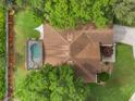 Aerial view of a well-maintained home with a private pool and lush landscaping, and mature trees at 165 Fig Tree Run, Longwood, FL 32750