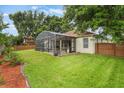 Large, grassy backyard featuring a screened-in pool, and mature trees perfect for outdoor enjoyment at 165 Fig Tree Run, Longwood, FL 32750