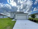 Two story home featuring a two-car garage, neutral paint scheme, and freshly cut lawn at 228 Aquamarine Ln, Kissimmee, FL 34758