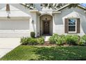 Close-up of the front door, garage, and landscaping, highlighting the home's curb appeal at 2718 Limerick Cir, Grand Island, FL 32735