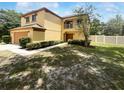 Charming two-story home with a balcony, two car garage, and fenced yard with trees at 281 Covent Gardens Pl, Deltona, FL 32725